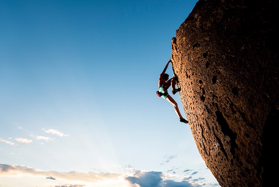 Person free-climbing up a mountain wall