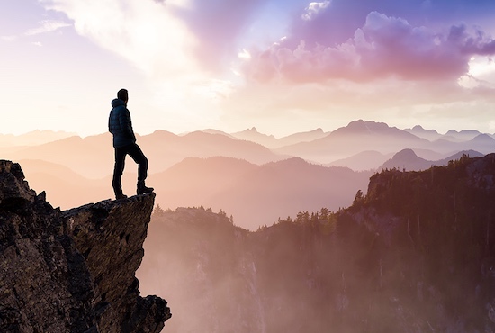 Hiker on top of mountain looking into the distance