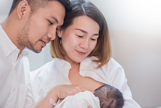 Couple looking at baby in their hands